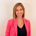 Mujer sonriente con chaqueta rosa en un fondo claro