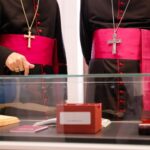 Dos personas con vestimenta religiosa en una exposición de biblias