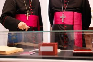 Dos personas con vestimenta religiosa en una exposición de biblias