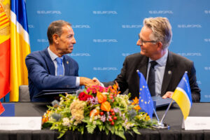 Dos hombres firmando un acuerdo entre la Policía de Andorra y Europol