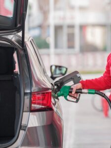 Persona llenando el tanque de un coche con gasoil en una gasolinera