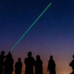 Personas observando estrellas con un láser en La Massana