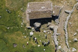 Vista aérea de un sitio arqueológico en Encamp con personas trabajando.