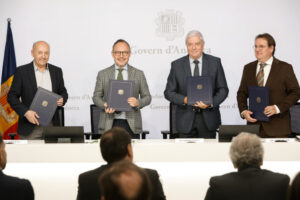 Cuatro hombres sostienen carpetas frente al emblema del Govern d’Andorra.