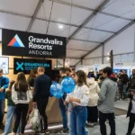 Personas se reúnen junto al estand de Grandvalira Resorts en un recinto ferial