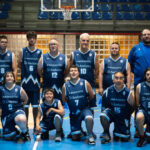 Grupo con camisetas del MoraBanc Andorra posa bajo una canasta en una pista cubierta.