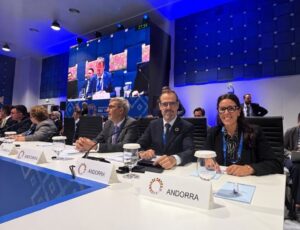 Participantes de Andorra sentados ante una mesa durante una reunión en una sala de conferencias