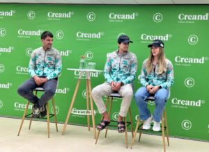 Tres personas sentadas ante un panel verde con logotipos de Creand.