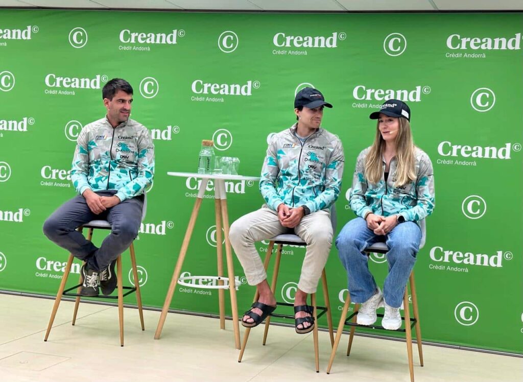 Tres personas sentadas ante un panel verde con logotipos de Creand.